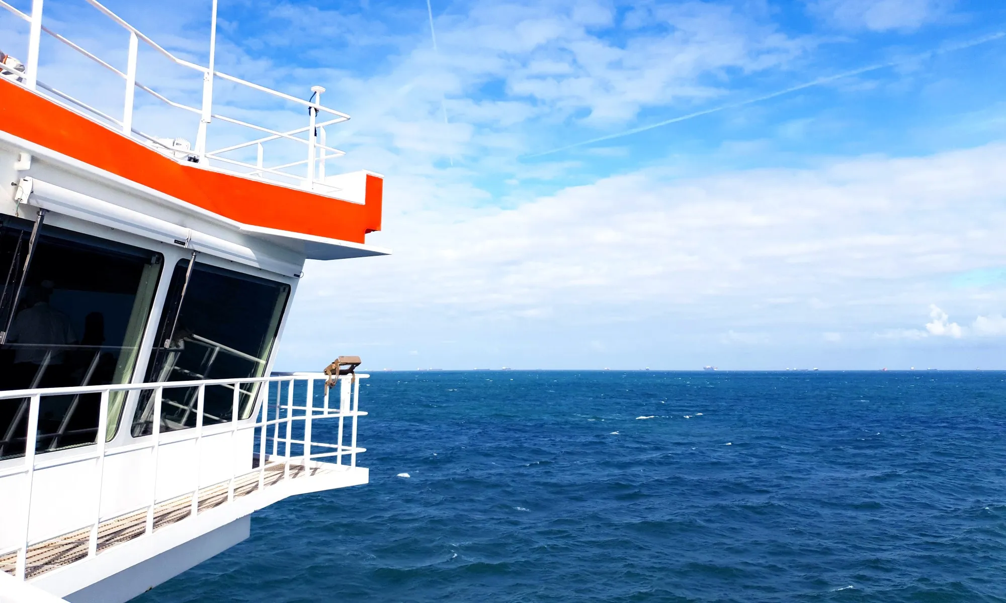Zicht vanaf de brug van een schip over de Noordzee, met schepen aan de horizon